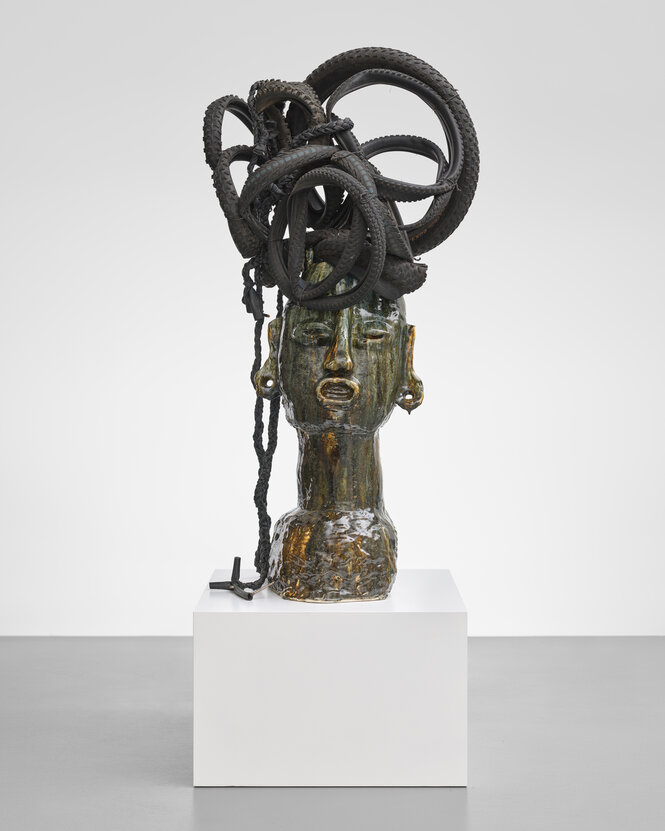 Eine Skulptur aus Keramik mit aufgetürmten Fahrradschläuchen auf dem Kopf von Leilah Barbiye.
