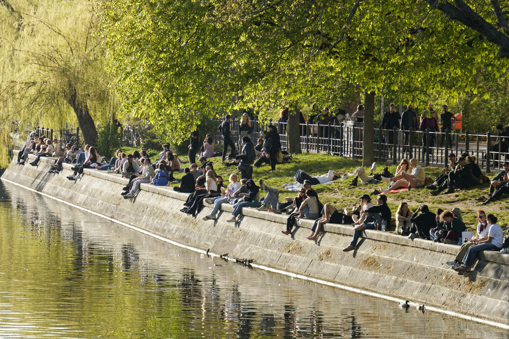 Menschen sitzen am Ufer des Landwehrkanals.