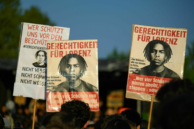 Menschen mit Schildern bei einer Demonstration.