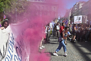 Personen mit Transparent und Megafon bei einer Demonstration.