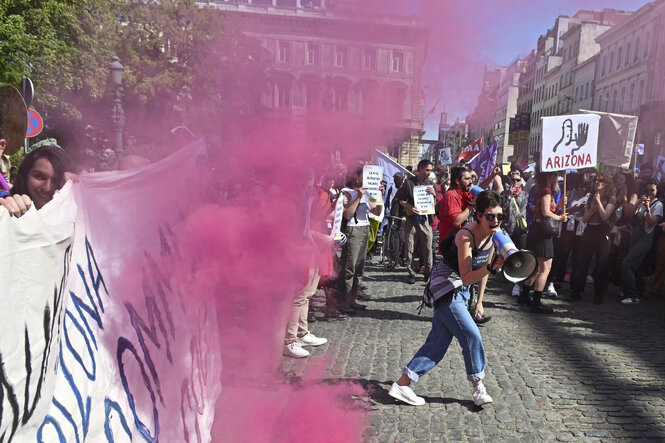Personen mit Transparent und Megafon bei einer Demonstration.