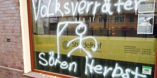 Ein Schaufenster, auf die Scheibe ist "Volksverräter Sören Herbst" geschmiert und ein Galgen mit einem Strichmännchen dran