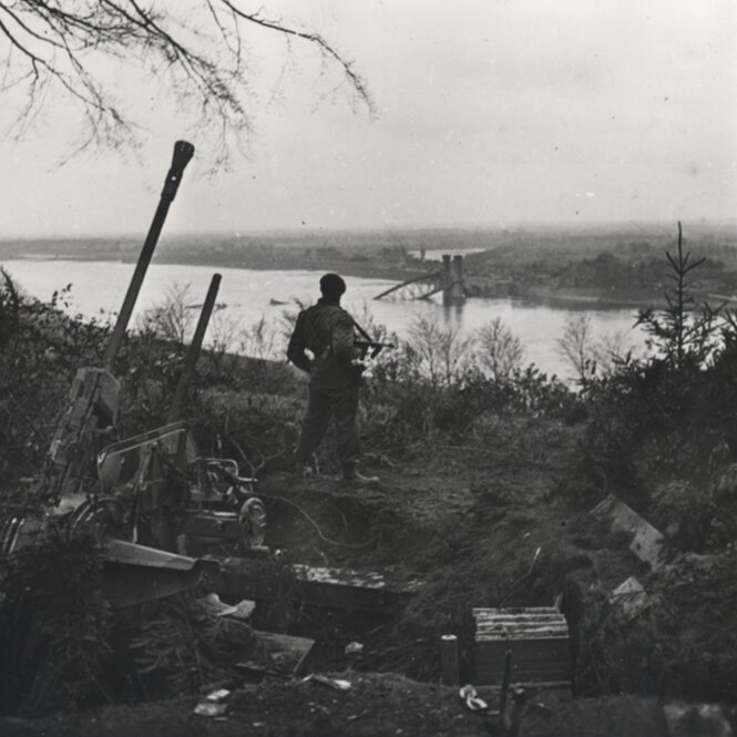 Ein Soldat blickt über die Elbe bei Laueneburg, eine Brücke ist zerstört, historische Aufnahme
