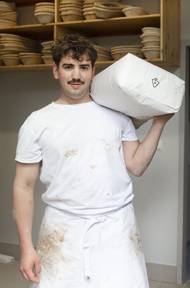 Ein Bäcker mit einem Sack mehl