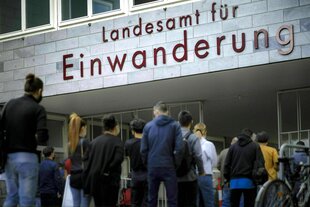 Menschen warten vor dem Eingang des Landesamts für Einwanderung