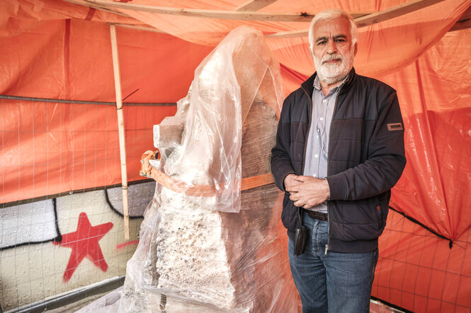 Kemal Karabulut, Gründer der Gemeinde steht neben dem tonnenschweren Sandsteinblock aus der Osttürkei, der ist noch in Plastikfolie eingewickelt