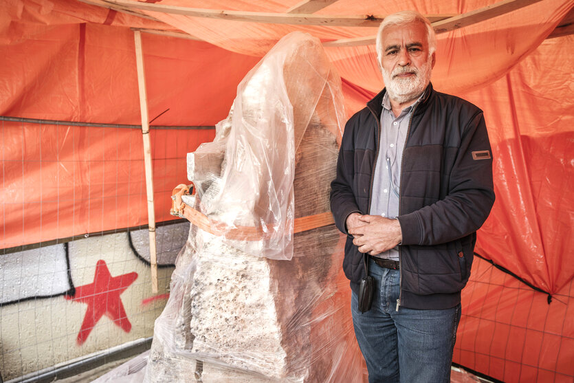 Kemal Karabulut, Gründer der Gemeinde steht neben dem tonnenschweren Sandsteinblock aus der Osttürkei, der ist noch in Plastikfolie eingewickelt