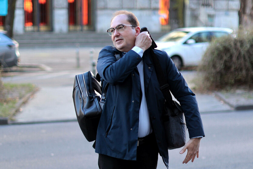 Alexander Dobridt steht am Straßenrand und schultert einen Rucksack