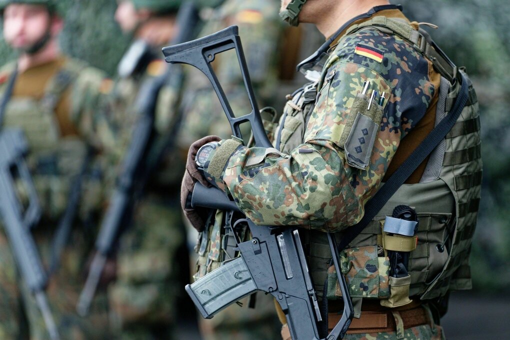 Bundeswehrsoldat:innen in Uniform und Maschienengewehr