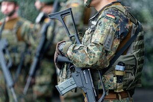 Bundeswehrsoldat:innen in Uniform und Maschienengewehr