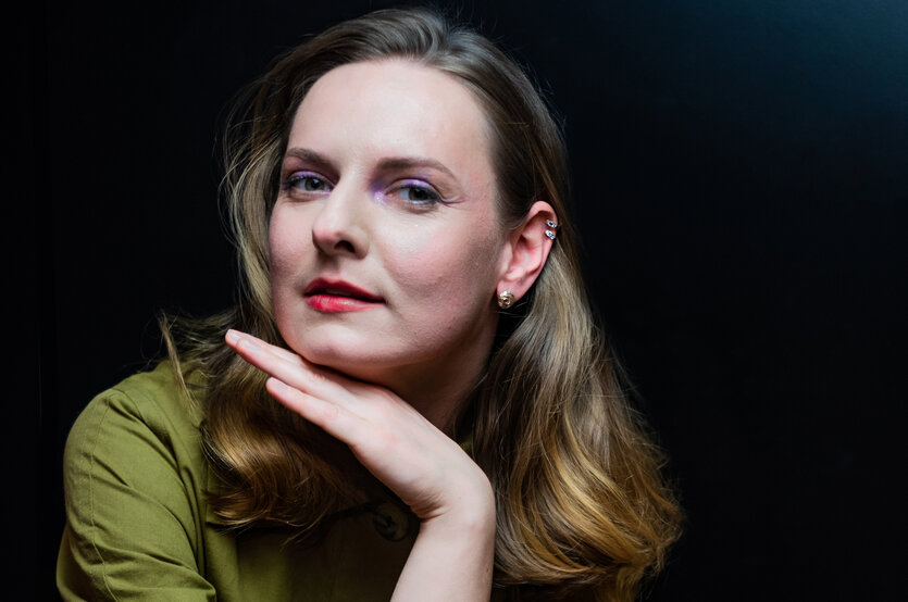 Viktoriia Vitrenko hat eine Hand unter ihr Kinn gestützt