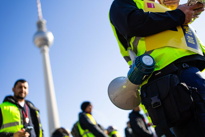 Demonstrant mit Megafon vor dem Berliner Fernsehturm
