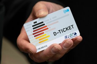 Eine Hand hält ein Deutschlandticket
