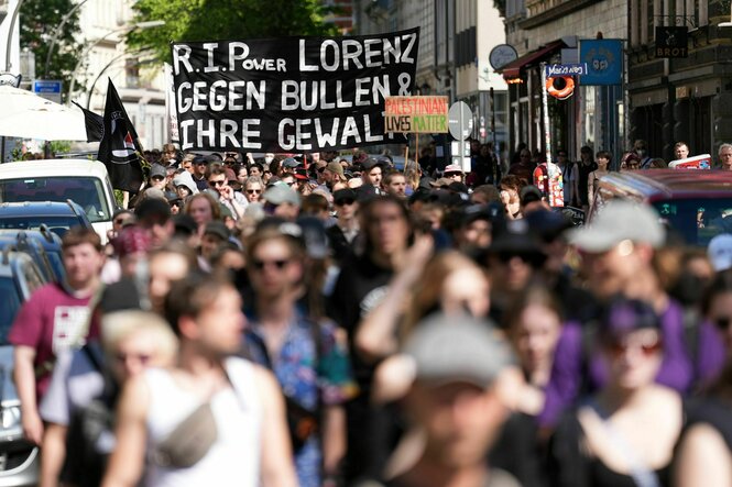 Demonstrant:innen mit einem Transparent, auf dem "R.I.Power Lorenz, gegen Bullen und ihre Gewalt"steht
