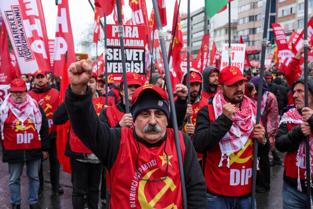 Menschen protestieren mit Plakaten und Fahnen