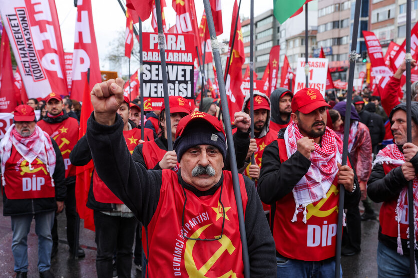 Menschen protestieren mit Plakaten und Fahnen