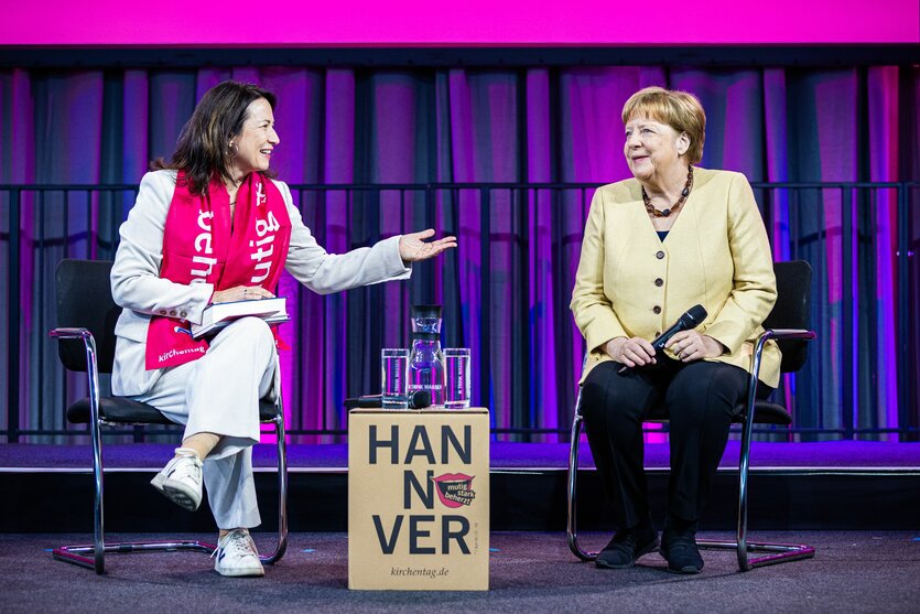 Altkanzlerin Angela Merkel sitzt neben der Kirchentagspräsidentin Anja Siegesmund