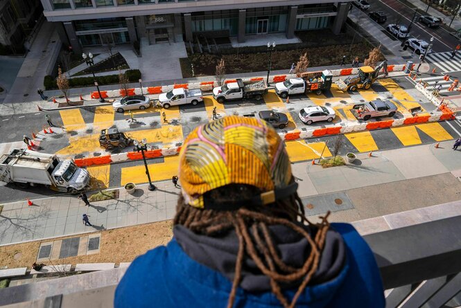 Man mit Dreadlocks schaut auf Baustelle