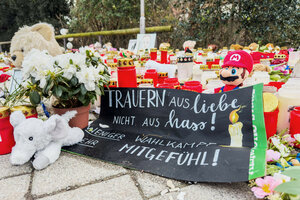 Blumen, Kerzen, Stofftiere und ein Banner 