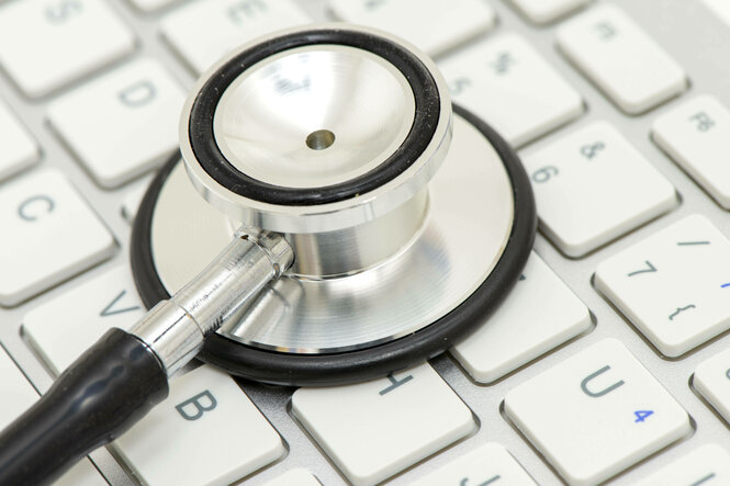 Ein medizinisches Stethoskop liegt auf einer Tastatur