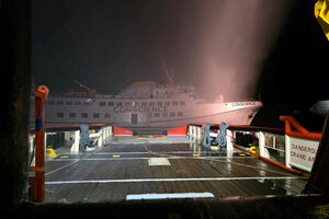 Ein Schiff undeutlich in der Dunkelheit. Rauchschwaden schweben in der Luft