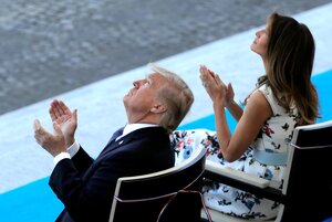 Donald und Melania Trump sitzen auf Stühlen und schauen in den Himmel, während sie in die Hände klatschen