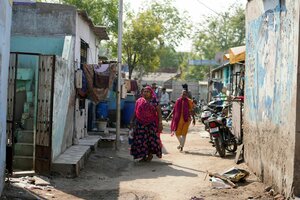 Menschen laufen durch das Viertel Vanzara Vas in der indischen Stadt Ahmedabad.