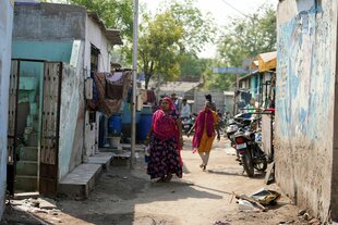 Menschen laufen durch das Viertel Vanzara Vas in der indischen Stadt Ahmedabad.