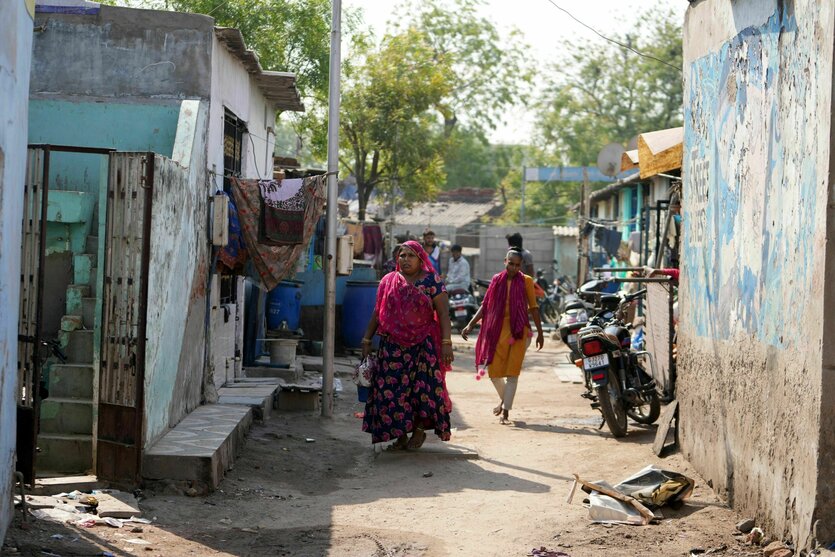 Menschen laufen durch das Viertel Vanzara Vas in der indischen Stadt Ahmedabad.