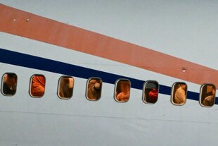 Menschen schauen aus einem Flugzeug