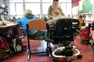 Eine Einzelfallhelferin spricht während des Unterrichts mit einem Kind mit Behinderung in der Rosa-Luxemburg-Grundschule in Potsdam