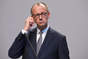 Friedrich Merz fasst sich an ein Ohrläppchen