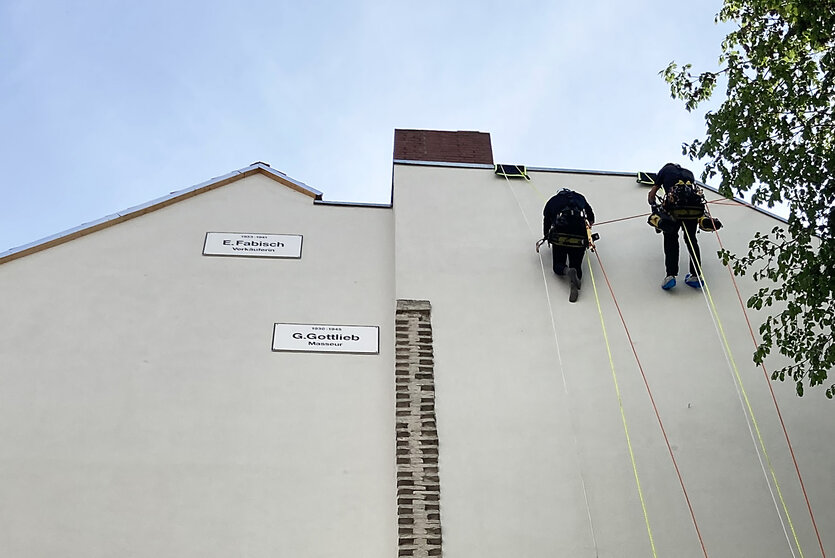 schlichte Texttafeln an der Wand eines Berliner Mietshauses