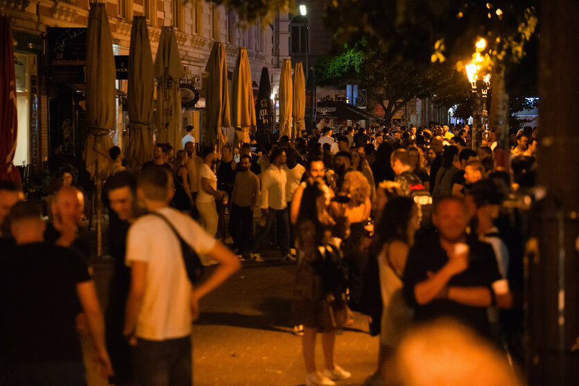 Menschen stehen teils dicht beieinander auf der Piazza am Schulterblatt.