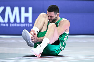 Ein Basketballer sitzt auf dem Court und hält sich den Fuß, das Gesicht schmerzverzerrt