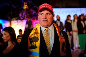 Mann mit Schal der rumänischen Partei und MAGA Baseballcap