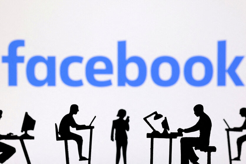 Figuren mit Computern und Smartphones sind vor dem Facebook-Logo zu sehen