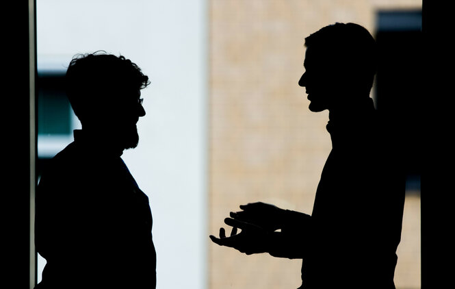 Zwei Männer diskutieren in einem Büro in Berlin miteinander.