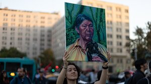 Eine Frau hält ein Plakat mit dem Konterfei von Julia Chunil