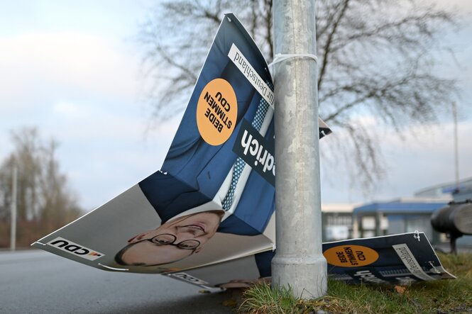 Ein beschädigtes Wahlkampfplakat des CDU-Vorsitzenden Friedrich Merz