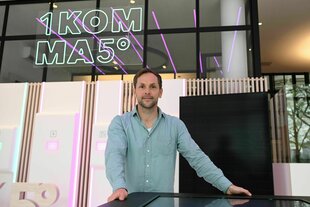 Philipp Schröder steht vor dem Logo seiner Firma 1Komma5Grad