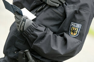 Ein Polizist kontrolliert einen Pass