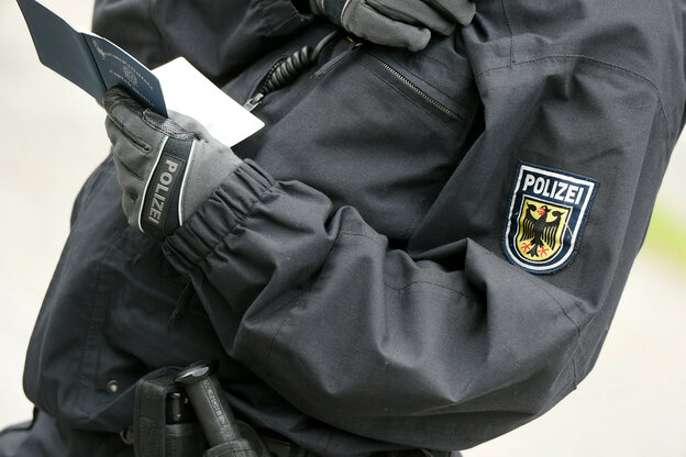 Ein Polizist kontrolliert einen Pass
