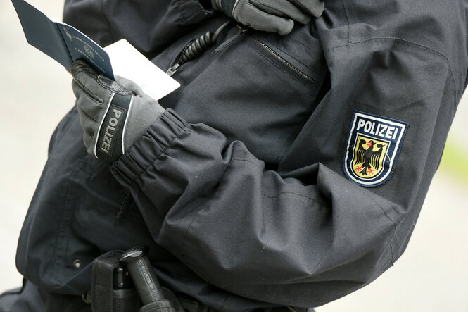 Ein Polizist kontrolliert einen Pass