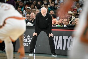 Im Vordergund zwei Baskenballerhintern. Dahinter Trainer Gregg Popovich