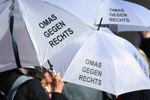 Man sieht drei weiße Regenschirme mit der Aufschrift 
