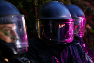 Polizeibeamt*innen in schwerer Montur mit Helmen und geschlossenem Schild bei einer Demonstration am 01.Mai 2025 in Berlin