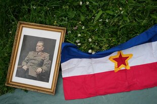 Gerahmtes Bild von Josip Broz Tito neben jugoslawischer Flagge