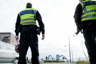 Beamte der Bundespolizei stehen (mit dem Rücken zur Kamera) bei der Einreisekontrolle am deutsch-polnischen Grenzübergang Stadtbrücke.