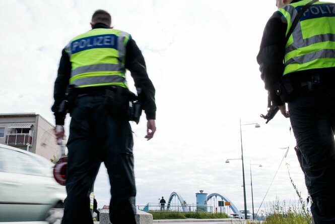 Beamte der Bundespolizei stehen (mit dem Rücken zur Kamera) bei der Einreisekontrolle am deutsch-polnischen Grenzübergang Stadtbrücke.